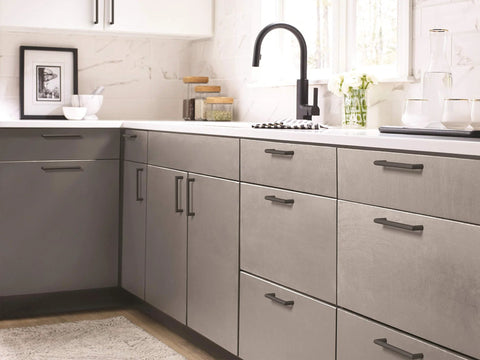 Modern kitchen featuring Matte Black Revolve Cabinet Pull 5-1/16 Inch Center To Center installed on gray cabinets and drawers.