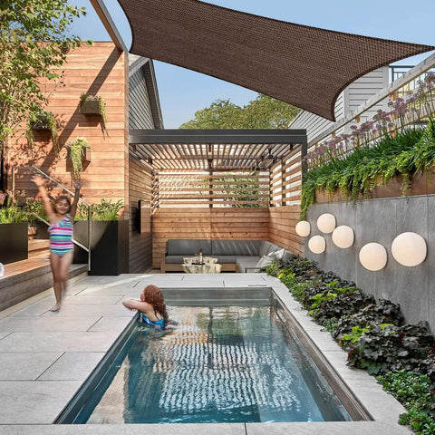 10x12 Brown Outdoor Shade Sail Canopy With UV Resistant Permeable Fabric for patio shading over a backyard pool and pergola.