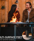 People sitting by 42 Inch Fire Pit Surround Tabletop Shield For Wood Burning Pits, Portable Protective Barrier with flame visible