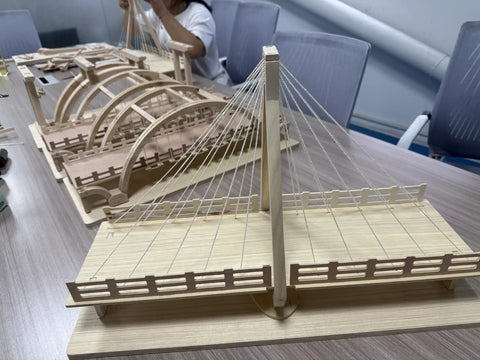 Detailed view of wooden bridge model with cables on a tabletop, ideal for DIY craft projects.