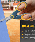 5-Inch Non-Stick Titanium Scissors With Glide Adjust Technology in use cutting blue paper in yellow and gray