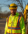 Worker wearing yellow helmet with Helmet Strap Mount Accessory With Two Magnetic Mounts And Screw In Feature for hard hats.