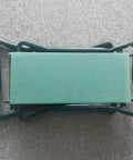 Garden Kneeler And Seat Heavy Duty Portable Folding Bench, shown folded, with green cushioned pad on carpet surface.