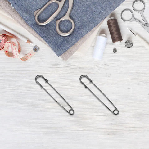 Premium Heavy Duty Safety Pins And Weatherproof Retro Brooches Perfect For Jackets Hats And Industrial Projects With Precision Opening Mechanism To Keep Everything Secure Anywhere on a crafting table with scissors and fabric.