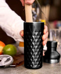 Person using Paragon Vacuum Insulated Cocktail Shaker With Built In Strainer in black, 23 oz double-walled stainless steel for cold drinks.