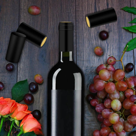 200 Piece Black Heat Shrink Wine Bottle Caps With Tear Tab 30Mm By 60Mm Pvc Shrink Sleeve Seals For Home Cellar, displayed on wooden surface with wine bottle and grapes.