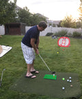 Man using Portable Indoor Golf Chipping Net With Hitting Mat For Backyard Practice, Fast Pop Up Setup, Rugged Canvas Target Net