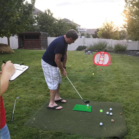 Man using Portable Indoor Golf Chipping Net With Hitting Mat For Backyard Practice, Fast Pop Up Setup, Rugged Canvas Target Net