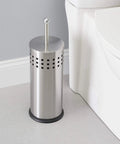 Slick Brushed Metal Toilet Plunger With Spill Proof Canister And Wall Mount Holder For Bathroom Corner Storage next to toilet.