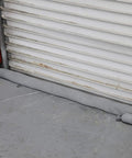 Heavy Duty Polypropylene Absorbent Socks For Flood Fighting Zero Sweat With Leaks Straight Up Industrial Grade Drain Guards blocking doorway.