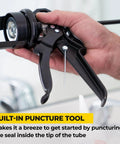 Close-up of black Heavy Duty Caulk Gun 29 Oz No Drip Design with a visible puncture tool in hand demonstrating use