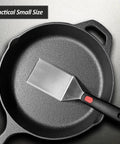 Heavy Duty Cast Iron Skillet Spatula With Full Tang Silicone Handle, Heat Resistant Commercial Grade Burger Press Spatula Flipper For Cooking And Serving, 2.7 Inch Wide shown in a skillet