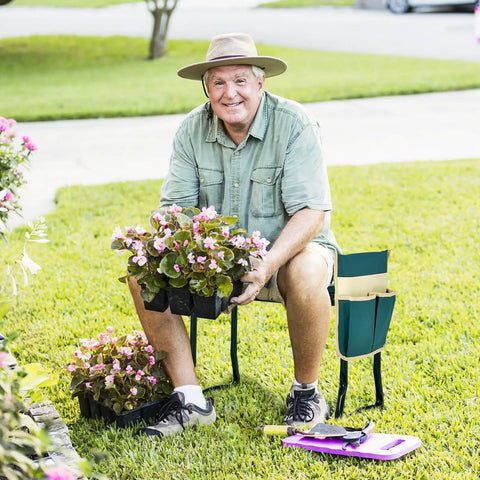 Man using the Garden Kneeler And Seat Foldable Bench with EVA Foam Pad, planting flowers in a garden, tool pouch attached.