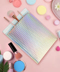 Dope Holographic Bubble Mailers 8 By 12 Inch 25 Pcs Metallic Bubble Mailers showcased with cosmetics on pink surface