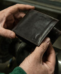Premium Full Grain Leather Men Passcase Wallet With A Rich Oil Tan Shell held by hands, showcasing sleek design and craftsmanship.