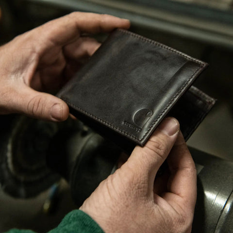 Premium Full Grain Leather Men Passcase Wallet With A Rich Oil Tan Shell held by hands, showcasing sleek design and craftsmanship.