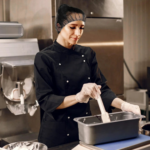 Person in kitchen wearing Disposable No Fuss Hair Nets For Food Service Black Nylon 28 Inch Pack Of 100 with Elastic Band