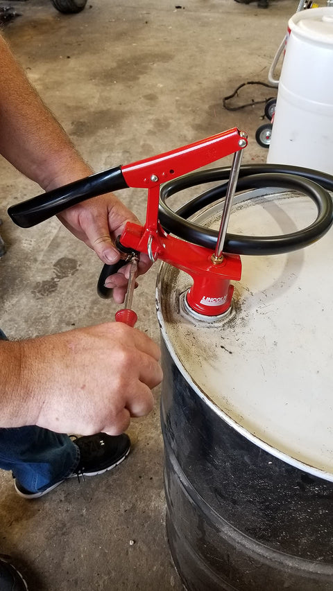 Lincoln 1335 Lever Action Fluid Transfer Pump for 16 to 55 Gallon Drums with 8.5 Fluid Ounces Per Stroke being used on a drum