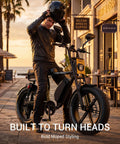 Man in a leather jacket with helmet on a Dual Battery Adult Electric Bike With 956 Wh Juice And A Mean 1800W Motor Logging Ninety Miles Smooth Full Suspension Hydraulic Disc Brakes 20X4 Fat Tires Moped Styled Build Long Bench Seat Tuned For Urban Adventures.