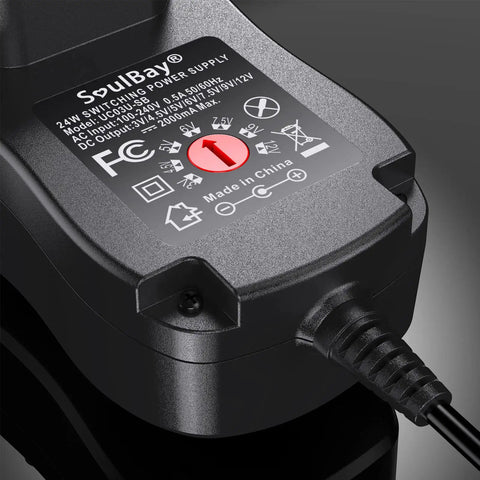 Close-up of Universal 24W Power Adapter with 8 selectable plugs, showing label with specifications and cable connection.