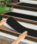 Applying Non Slip Outdoor Stair Treads 6x24 Inches Black 8 Pack Pre Cut 80 Grit Anti Slip Grip Tape on wooden steps