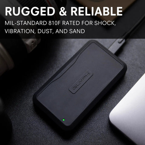 Beast 2TB External NVMe SSD With Thunderbolt 3 Ultra Fast 2800 MBs Read 2600 MBs Write For 4K 8K Editing VR And Big Media Backups Fanless Rugged Aluminum Enclosure Meets MIL STD 810F black SSD on desk
