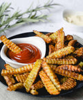 Triangle Crinkle Cutter - crispy crinkle-cut fries with red ketchup on a black plate