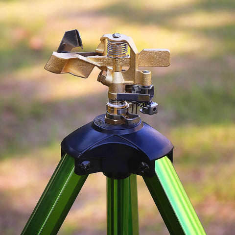 Impact Sprinkler On Tripod Base With Stakes For 360 Degree Lawn Irrigation, Brass head on a green tripod in garden setting