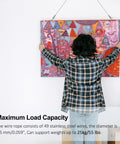 Person hanging art with Stainless Steel Picture Hanging Wire Kit, 25Kg Load, 2 Pack, Adjustable 2M Wire Rope With D Ring