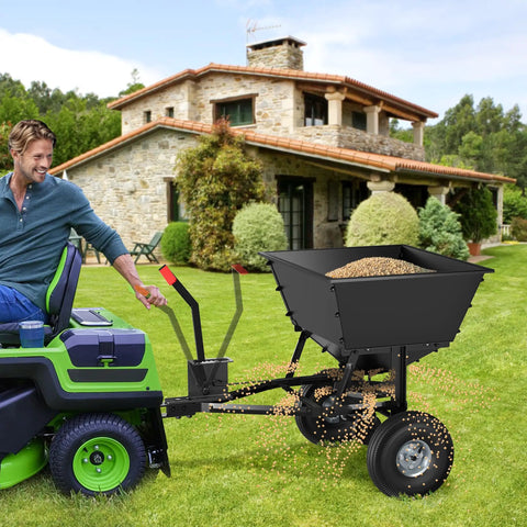 Beefy Built Tow Behind Broadcast Spreader for Lawn and Garden with 130 lb capacity attached to a lawn tractor on grass