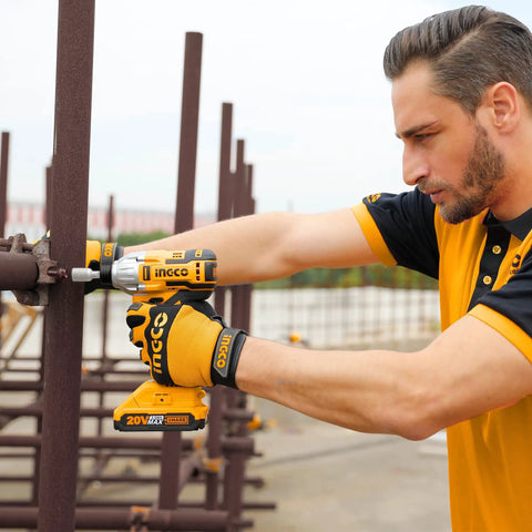 Man using 20V Cordless Brushless Impact Driver Set with 1/4 Inch Drive, compact build for metalwork, outdoor scene