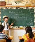Classroom with Vintage Travel Bulletin Board Border Roll With World Map Adventure Motifs, children at chalkboard lesson.