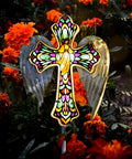 Solar Glass Cross Garden Stake Light with Angel Wings and Stained Glass Look in a garden with marigolds at dusk.