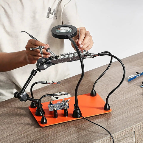 Magnetic Helping Hands Soldering Station With 3X LED Magnifying Lamp, 4 PCB Holders in use for electronics repair on table