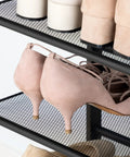Close-up of shoes on Five-Tier Entryway Shoe Rack With Adjustable Mesh Shelves Industrial Metal Design Holds 16-20 Pairs Of Shoes Floor Mount Rustic Brown Organizer For Closet Or Hallway.