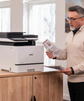 Man using Color Laser All In One Printer With Duplex Printing, Scan And Copy, Fast 33 Pages Per Minute in office