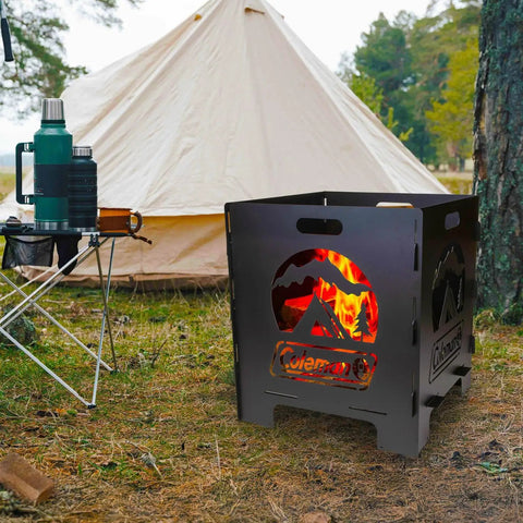 20 Inch Portable Wood Burning Fire Pit Collapsible For Camping And Backyard Use Tailgate Ready Ultra Compact Easy Assembly With Interlocking Design Great For Deck Or Patio Black shown in a campsite with a tent and trees in the background.