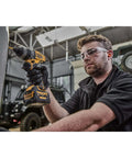 Man using Compact 12V Cordless Drill Driver Workhorse with right angle bit for tight spaces in a workshop setting.