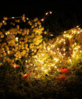 Fairy String Lights 33 Ft 100 LEDs Copper Wire Plug In Indoor Outdoor With 8 Lighting Modes And Memory Function glowing in garden