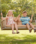 Children sitting on a Wicker Porch Swing With Cushioned Seat And Armrests Hangout Ready Outdoor Hanging Swing Bed with Steel Chains in a garden.