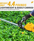 Person using 52cm Cordless Hedge Trimmer With Rotatable Handle And Brushless Motor For Garden And Yard, cutting green hedges.