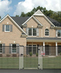 Front view of a brick house with a metal mesh fence and gate.