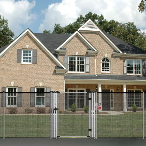 Front view of a brick house with a metal mesh fence and gate.