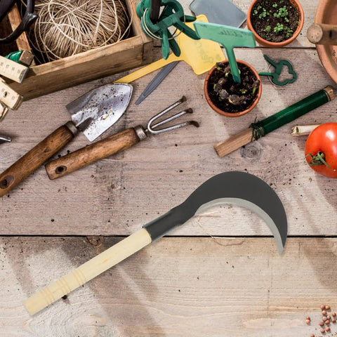 Beefy Long Handle Manganese Steel Hand Scythe For Weeding And Lawn Care Black Half Moon Blade against garden tools on wood table.