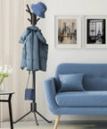 Tree Shaped Coat And Hat Organizer Rack With Eighteen Hooks For Entryway Or Bedroom Dope Space Saving Stand To Hang Coats Hats Scarves And Bags In Black Finish beside a blue sofa.