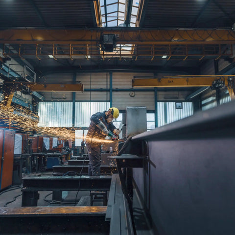 Worker using Beast Power 6 Inch 2000 Watt Brushless Angle Grinder For Industrial Use With Marathon Brushless Motor Efficient Dust Protection Quick DS BL WEPBA 20 150 Model Compact Yet Powerful Tool For Heavy Duty Cutting And Grinding in a factory