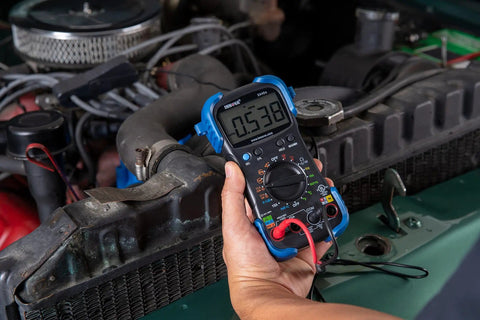 Person using Pro Grade Automotive Digital Multimeter with Auto Range and Overload Protection in engine diagnostics