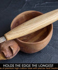 Dead Reliable Wood Carving Hook Knife For Spoon Whittling And Bowl Crafting Single Bevel Razor Sharp High Carbon Steel Blade placed on curved wooden bowl.