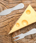 Cheese Knife And Butter Fork Set Stainless Steel With Easy Cutting And Easy Cleanup, on a wooden surface with cheese slice.