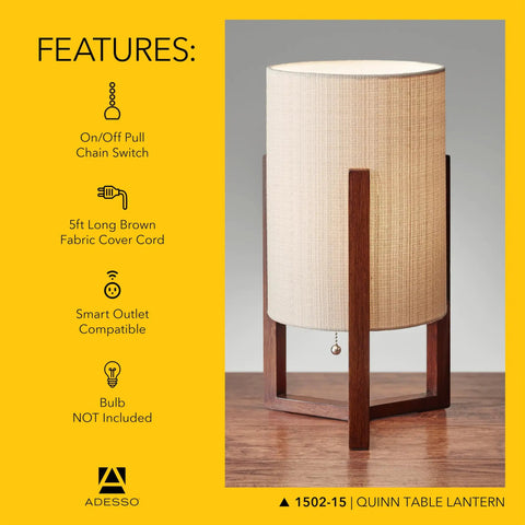 Quinn Table Lantern With Walnut Birch Wood Crisscross Base And Natural Linen Shade sitting on wooden surface